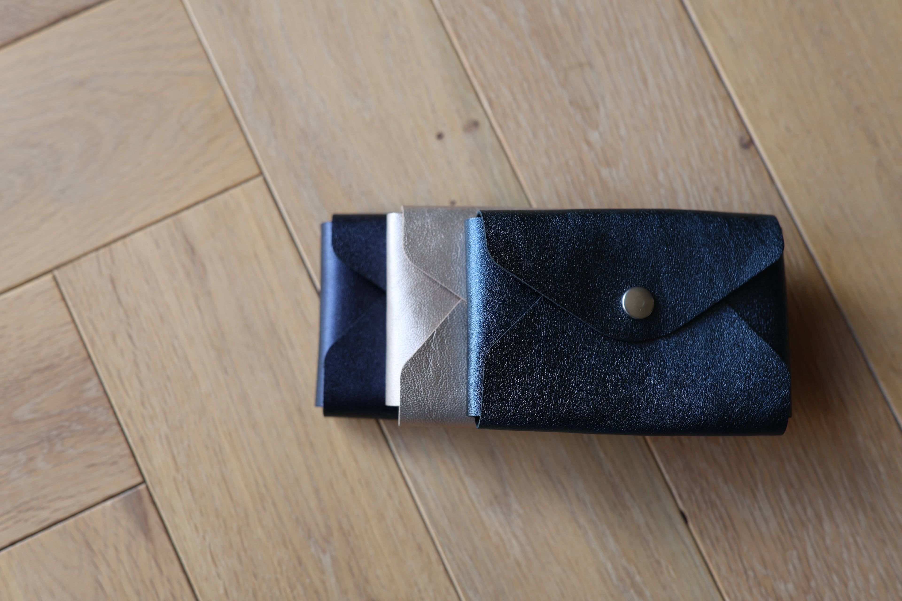 Pochette plate La Balzacienne en cuir véritable violet irisé, confection artisanale, ensemble des modèles