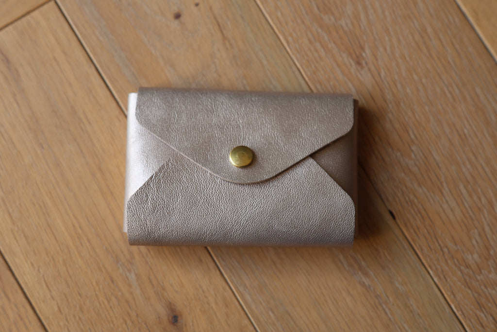 Pochette plate La Balzacienne en cuir véritable champagne irisé, créer près de Chartres, devant