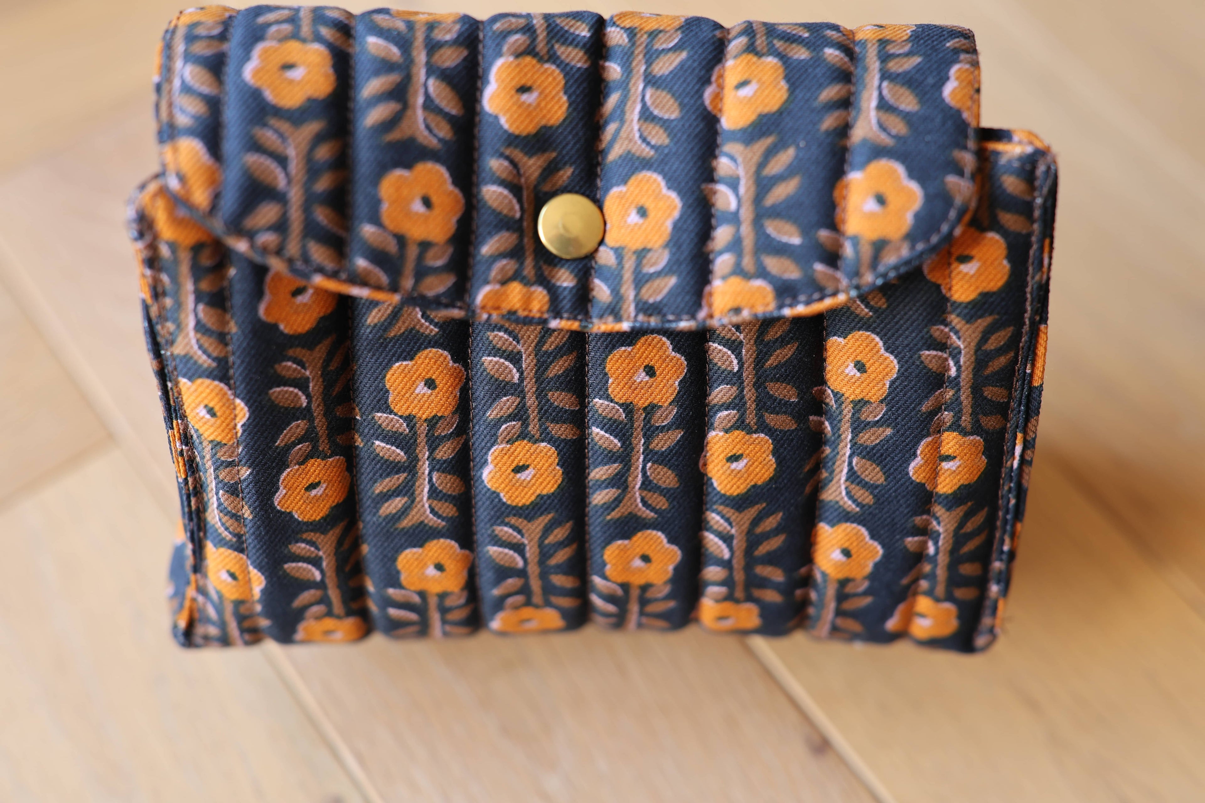 Pochette matelassée La Cachottière en coton motif indien, création textile artisanale, détail bouton